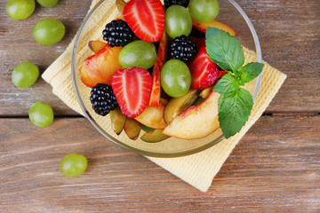 fresh tasty fruit salad on wooden table