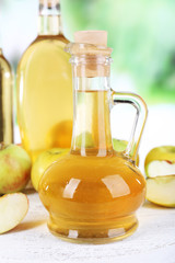 Apple cider vinegar in glass bottles and ripe fresh apples,