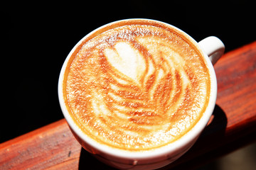 Cup of coffee with cute drawing in cafe