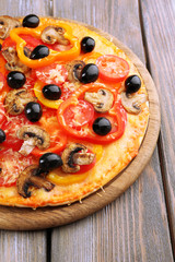 Delicious pizza served on wooden table