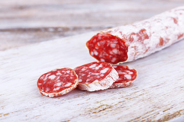 French salami on cutting board on wooden background