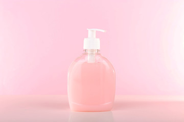 Liquid soap in plastic bottle on pink background
