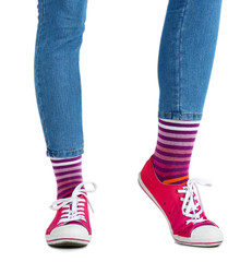 Female legs in colorful socks and sneakers isolated on white