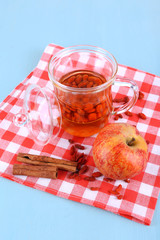 Goji berries drink in glass cup, ripe apple and cinnamon