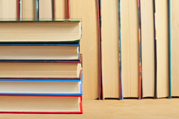 Pile of books on a wooden surface against the background of a nu