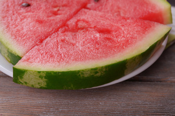 Slices of watermelon on plate on wooden table