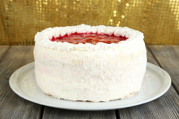 White cake on table on golden background