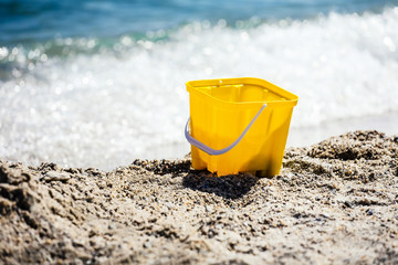 Fototapeta na wymiar Summer vacation concept. Toy bucket on beach.