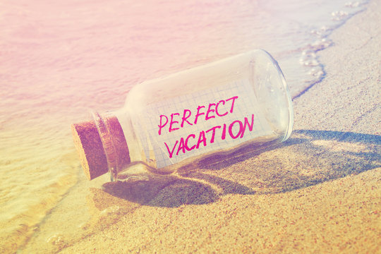 Message in a bottle "Perfect vacation" on beach. 