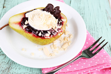 Tasty dessert with pear, cream and berry sauce