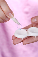 Woman holding container with contact lenses, close-up