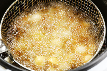 Dumplings in deep fryer, closeup
