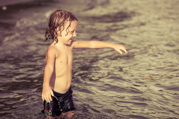 Fototapeta premium little boy playing on the beach at the day time