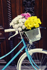 Fototapeta na wymiar Old bicycle with flowers in metal basket
