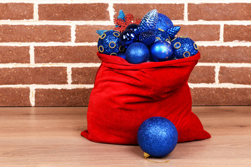 Red bag with Christmas toys and gifts in room