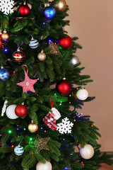 Decorated Christmas tree on light brown background