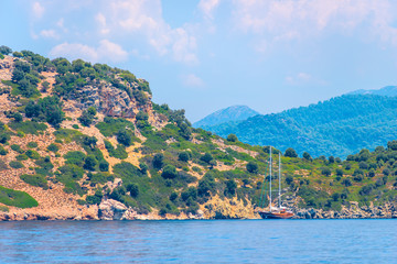Fototapeta premium lonely sailing yacht moored to a rocky shore