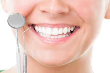 Closeup of perfect smile and dentist tools.