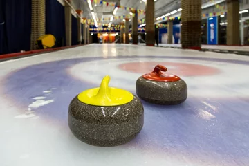 Fototapeten Curling stones on an indoor rink © Sergey Lavrentev