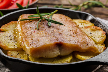 Baked fish fillets with potatoes in a frying pan