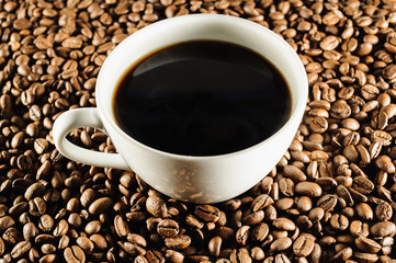 white cup of coffee on coffee beans