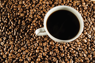 white cup of coffee on coffee beans