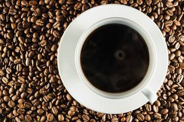 white cup of coffee on coffee beans