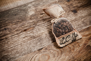 Coffee beans in bag on wooden table