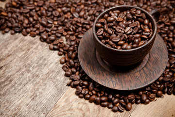 Coffee cup with coffee beans on wooden table
