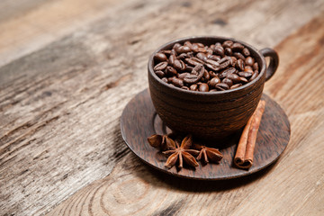 Coffee cup with coffee beans on wooden table