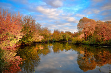 Landscape with colorful autumn trees reflected in the river