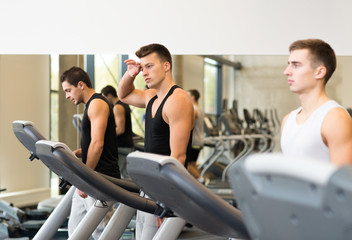 Fototapeta na wymiar group of men exercising on treadmill in gym