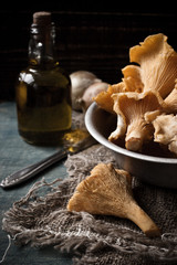 Chanterelle mushrooms in a dish on the table and an oil bottle