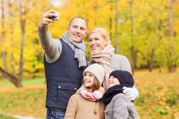 happy family with camera in autumn park