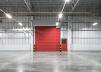 Rolltor oder Rollladen in Fabrik, Lager oder Industriegebäude. Modernes Innendesign mit poliertem Betonboden und leerem Raum für Produktpräsentation oder Industriehintergrund.