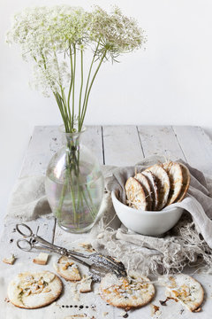 homemade cookies on bowl on white wooden table with wildflowers