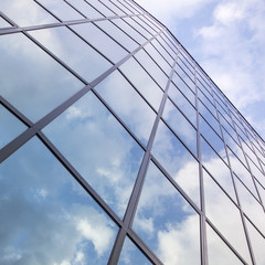 reflexions of clouds and blue sky in facade of modern building