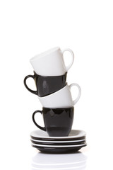 Black and white cups on the stack of the plates.