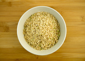 Pile of raw brown rice in a white bowl