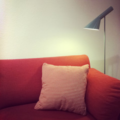 Red sofa with cushion and lamp