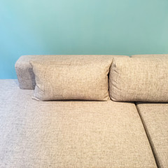Sofa with cushions near green wall
