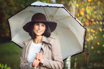 Beautiful woman with umbrella in autumn park