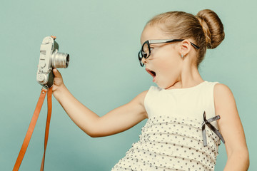 child holding a instant camera - obrazy, fototapety, plakaty
