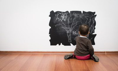 Little girl drawing the wall