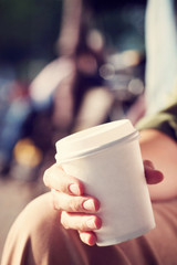 Young woman drinking coffee from disposable cup