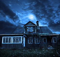 the moon in a cloudy sky, above the old wooden house