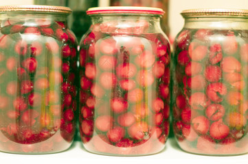 Canned red cherries in a glass jar