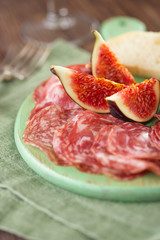 meat platter of Cured Meat and figs on green wooden board