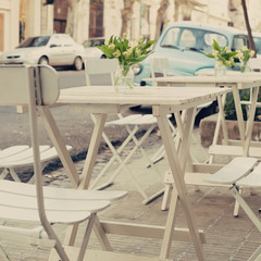 White vintage wood cafe tables in a sidewalk