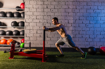 sled push man pushing weights workout